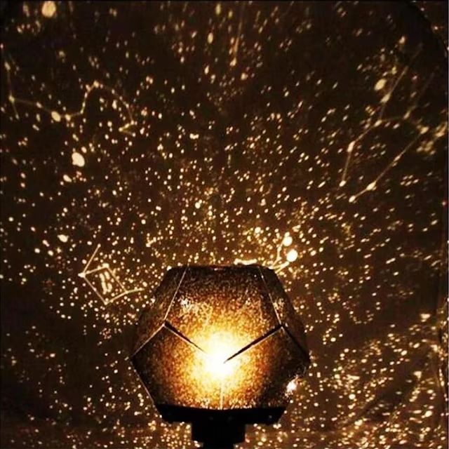 a light that is sitting on top of a wooden table with stars in the background