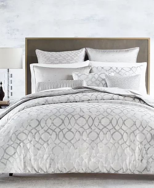 an image of a bed with white and grey comforter