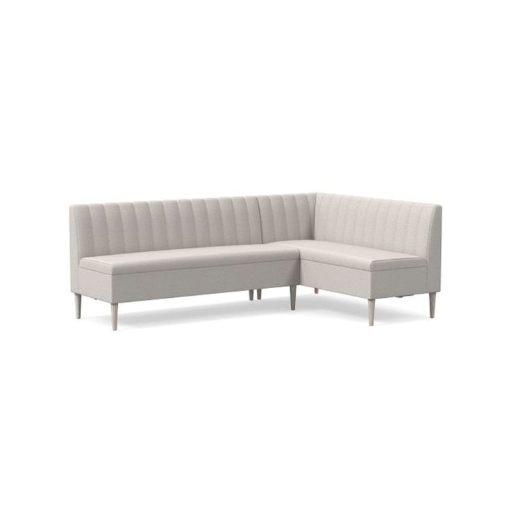 a white sectional couch sitting on top of a white floor