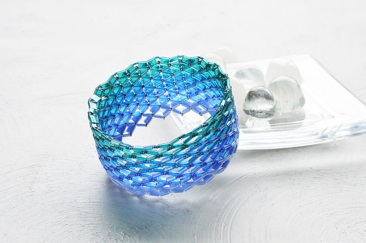 a blue ring sitting on top of a table next to an ice cube and spoon