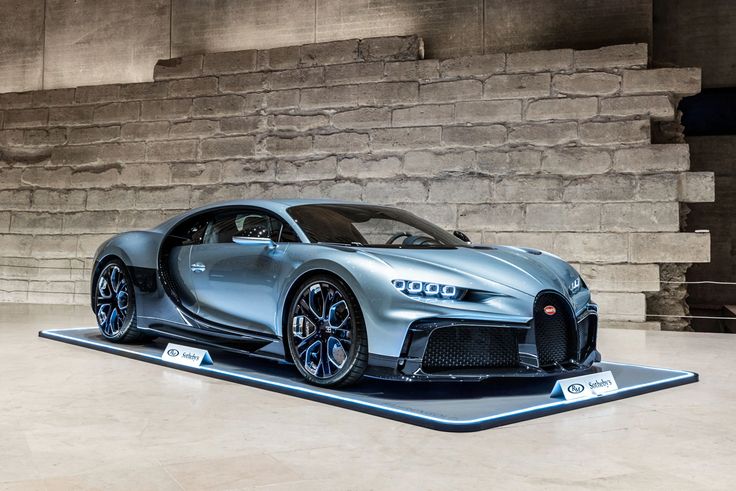 a bugatti car on display in front of a stone wall and floor area