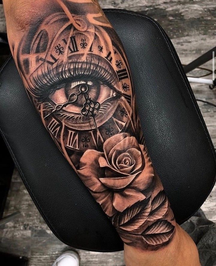 a person with a clock and rose tattoo on their arm