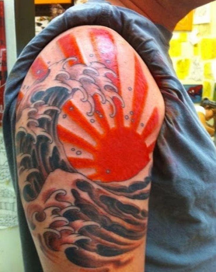 a man with a tattoo on his arm that has an image of the sun and waves