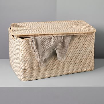 a large woven basket sitting on top of a white table next to a gray wall