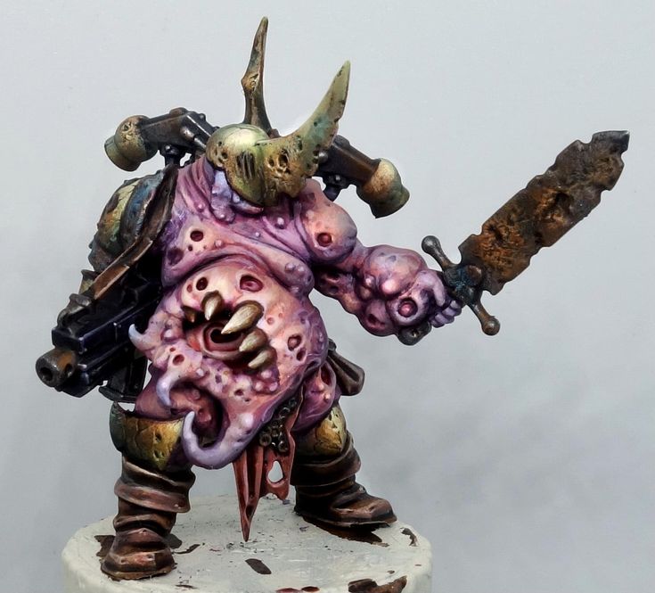 a painted warhammer with two large horns on it's head, holding a knife