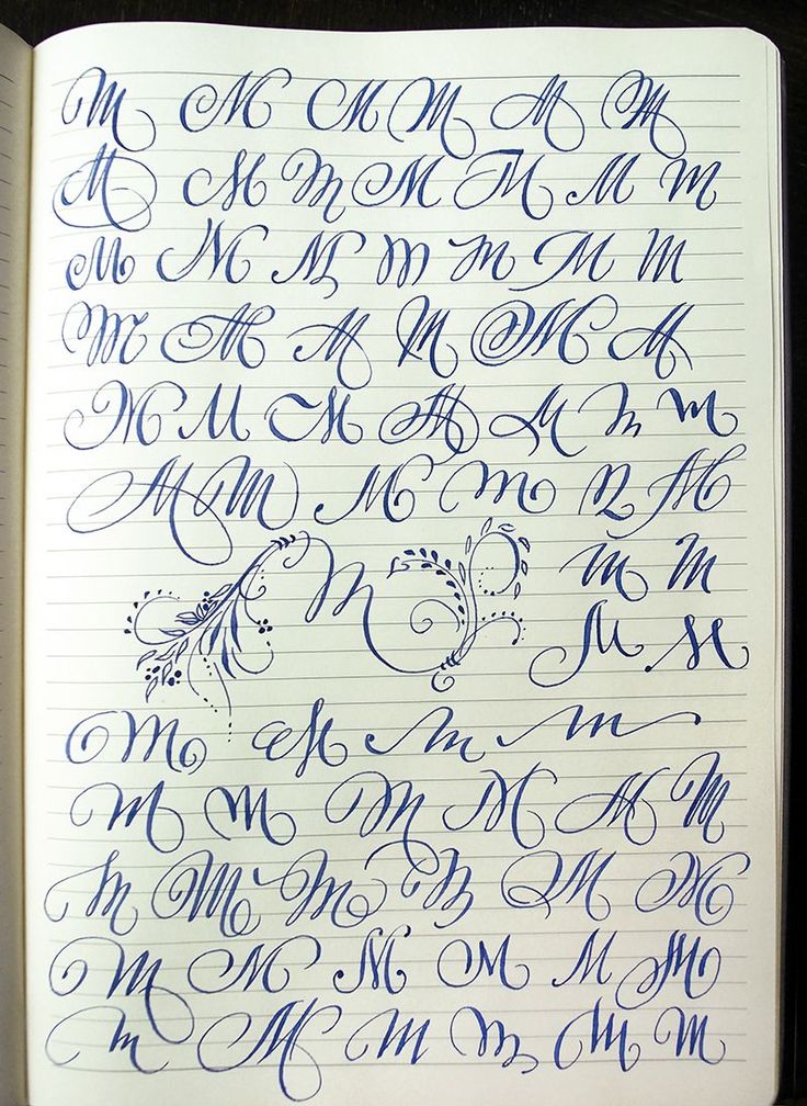 an open notebook with cursive writing on it and the letter m in blue ink