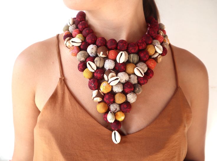 Out of Africa comes a tribal necklace design which has inspired our own tribal women to create a magnificent bead and shell statement piece. Made from various colors for one piece, indigo blue for another, burgandy and mustard for a third. Or we can make a necklace matching one of the four seasons color chart: Spring, Summer, Autumn, or Winter. Enjoy wearing this unique Necklace Earring Set anytime of year.  Stand out with a lightweight Colorful Yellow necklace of hand made cotton beads  of Upcy Recycled Necklaces, Make A Necklace, Necklace Matching, Yellow Necklace, Cowrie Shells, Out Of Africa, Necklace Design, Indian Fabric, Unique Necklace