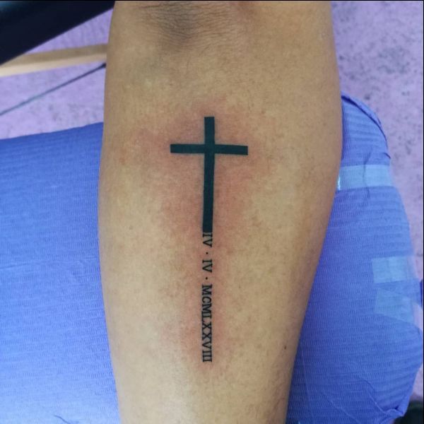 a person with a cross tattoo on their leg