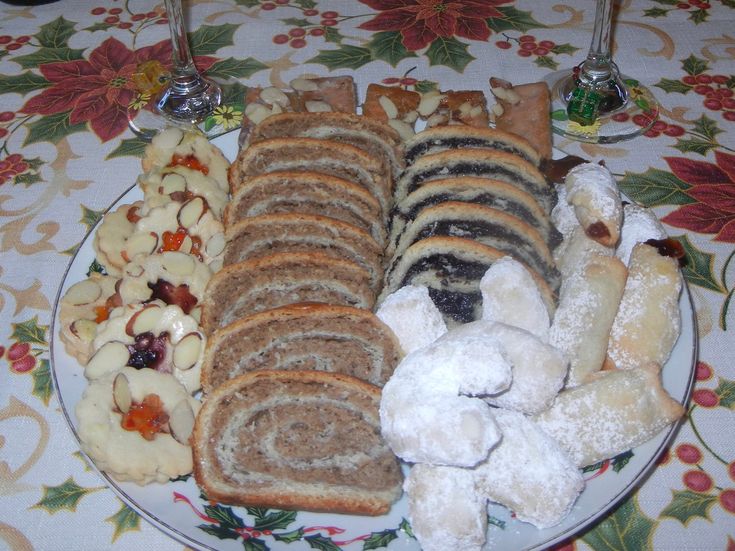 a plate full of different kinds of breads and pastries on a tablecloth