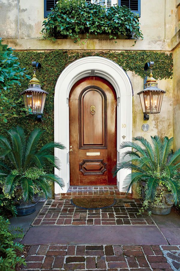 an entrance to a home with potted plants on either side