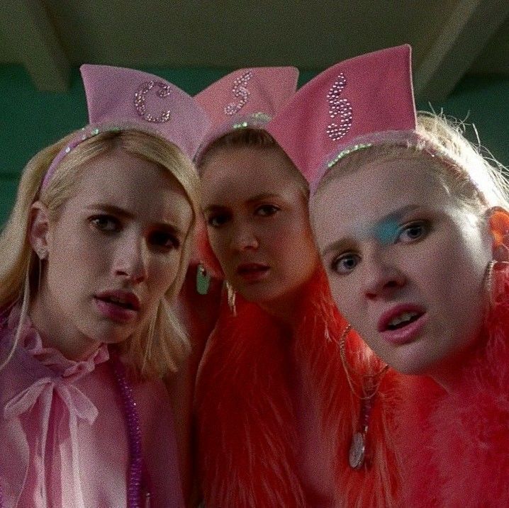 three girls in pink costumes and tiaras posing for the camera