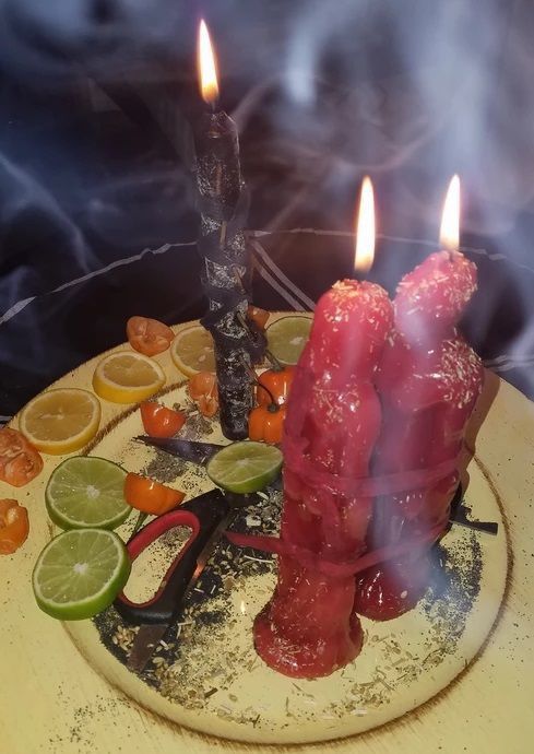 a plate with some meat on it and two candles in the middle, surrounded by other food items