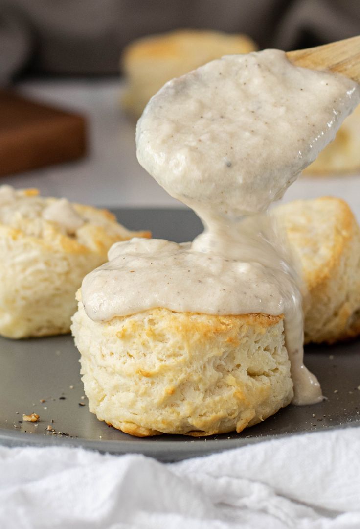 biscuits being drizzled with icing on top of each other and placed on a plate