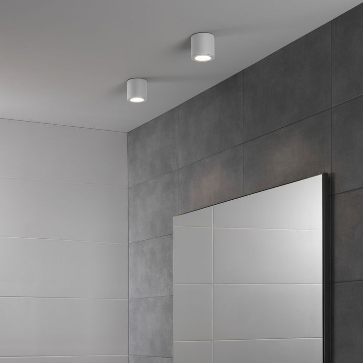 a white sink sitting under a bathroom mirror next to a wall mounted faucet