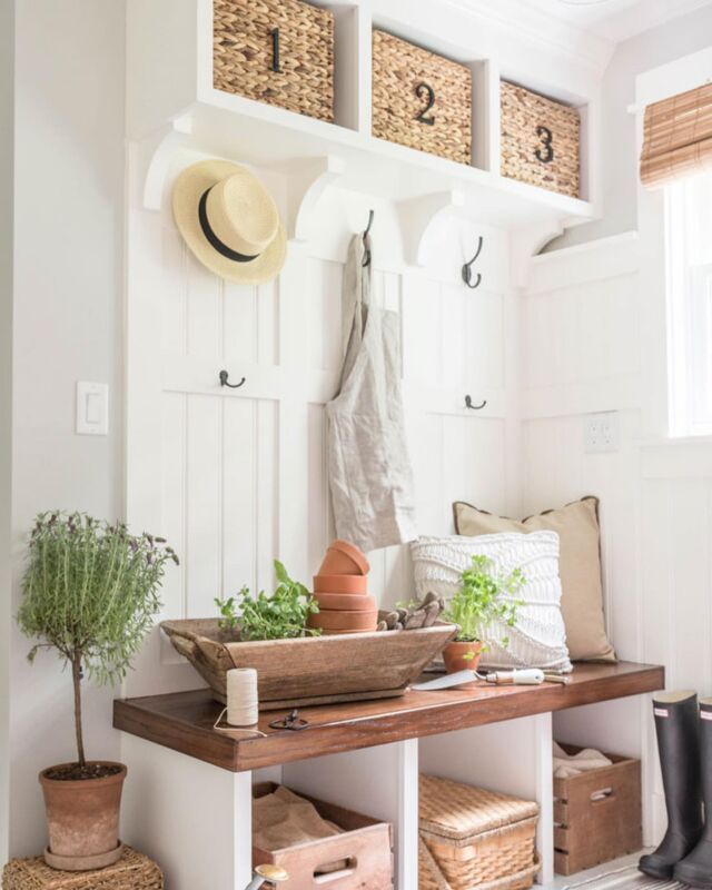 an entryway with baskets and plants on the shelf, along with other storage bins