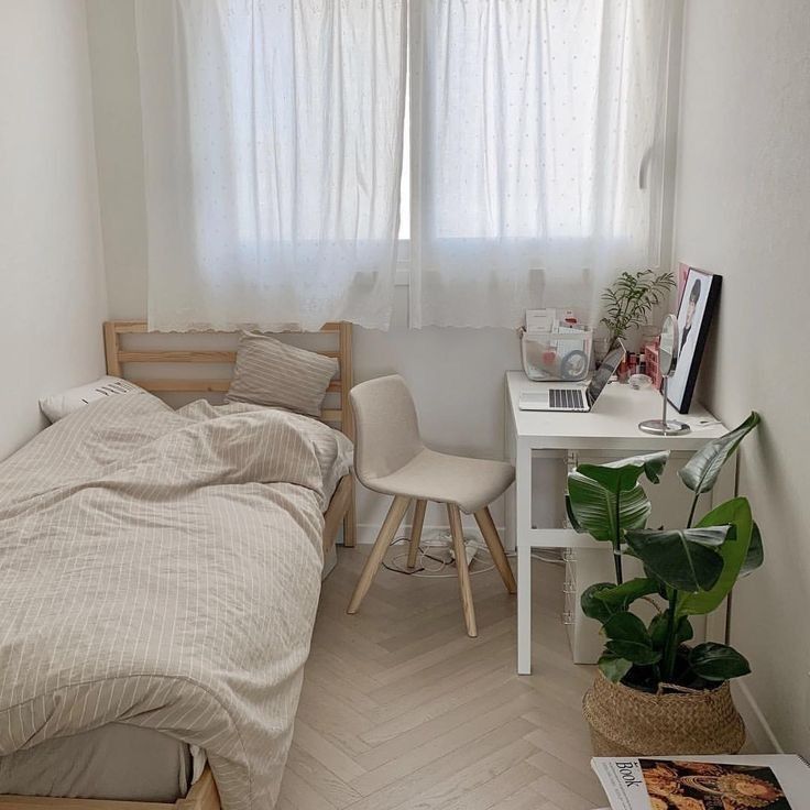 a small bedroom with a bed, desk and chair