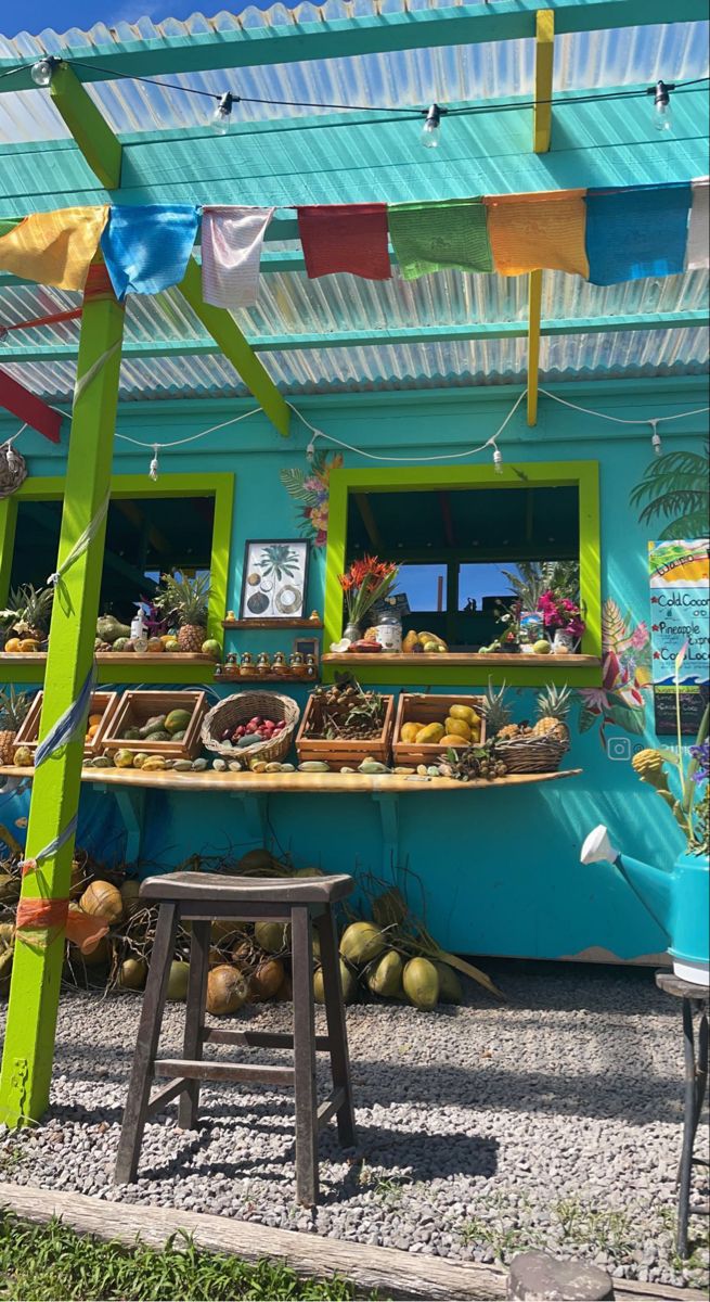 an outdoor fruit stand with lots of fresh fruits and vegetables on display in front of it