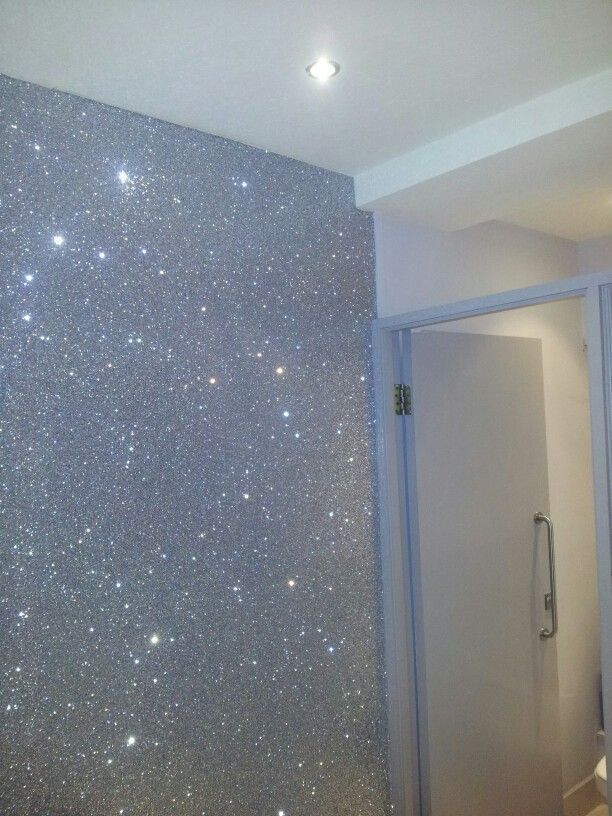 a bathroom with silver glitter on the wall and toilet in the corner next to it