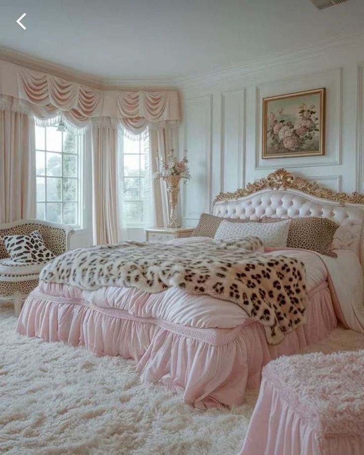 a bedroom decorated in pink and white with leopard print on the bed, chair, rugs and windows