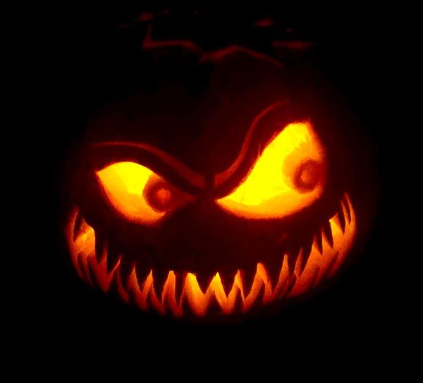 a carved pumpkin with an evil face on it's side and eyes glowing in the dark