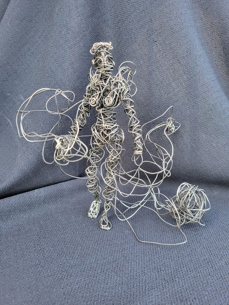 a wire sculpture sitting on top of a blue cloth