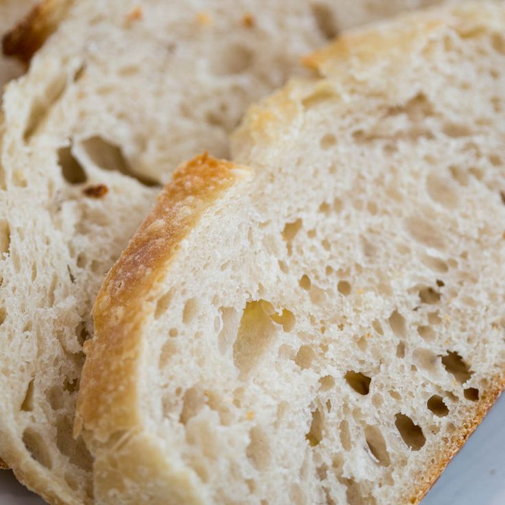 two pieces of bread sitting on top of a white plate next to another piece of bread