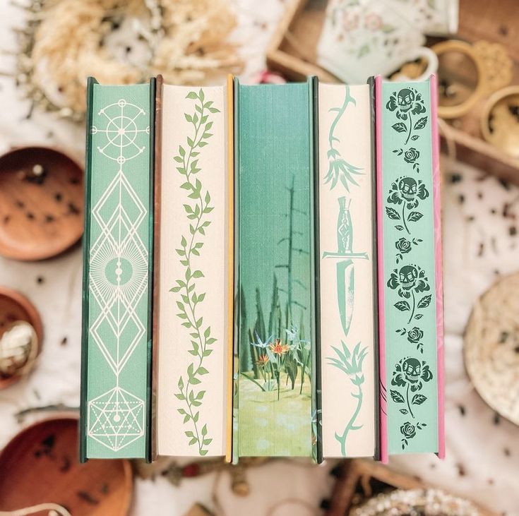 four books sitting on top of each other in front of some bowls and spoons