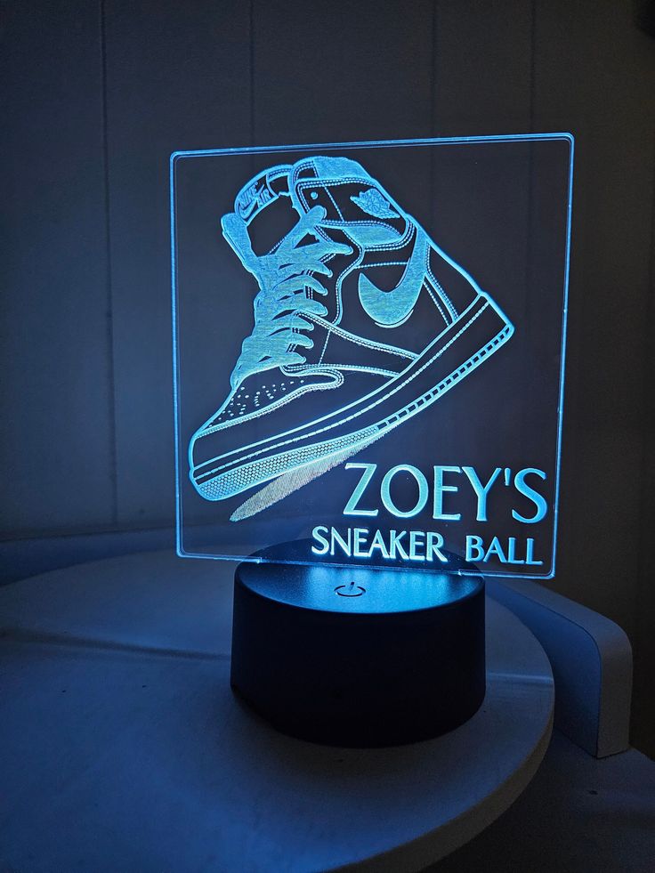 a light up sneaker ball lamp on top of a table with the words, zooey's sneaker ball