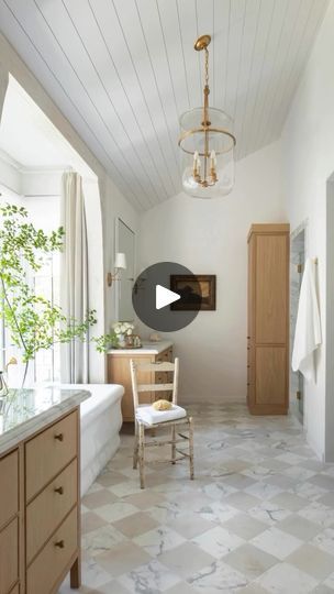 a large bathroom with a tub, sink and mirror in it's center area