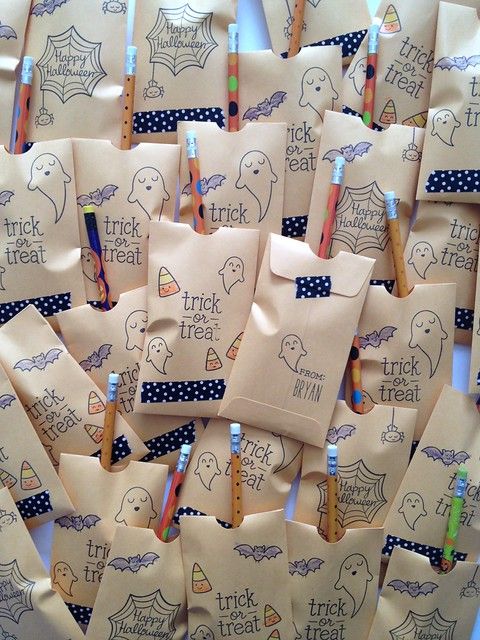 many small bags with writing on them are lined up in the shape of halloween treat bags