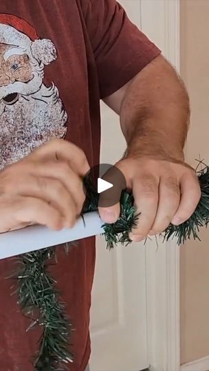 a man holding a pair of scissors in front of his face with christmas decorations on it