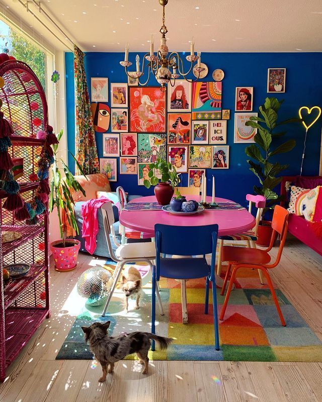 a brightly colored dining room with lots of pictures on the wall and colorful rugs