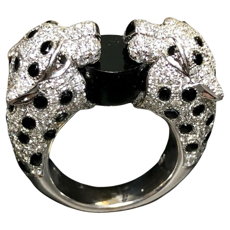 A beautifully made ring crafted in 18K white gold set with approximately 3cttw in G-H color Vs1-2 clarity round diamonds as well as black diamonds for the eyes. A custom cut piece of natural black onyx is positioned between their mouths and meticulously applied black enamel for its spots. A superb piece. Dimensions/Weight: Ring measures .40” top to bottom and 1” wide. Ring is a size 6.5 (sizable) and weighs 19g. Condition: All stones are secure and enamel is in perfect condition. R-CYY White Gold Set, Wide Ring, Ring Crafts, Black Diamonds, Gold Set, Cocktail Ring, Black Enamel, Cocktail Rings, Black Diamond