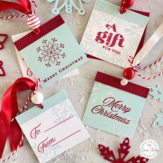 christmas cards with red ribbons and snowflakes on the table next to each other