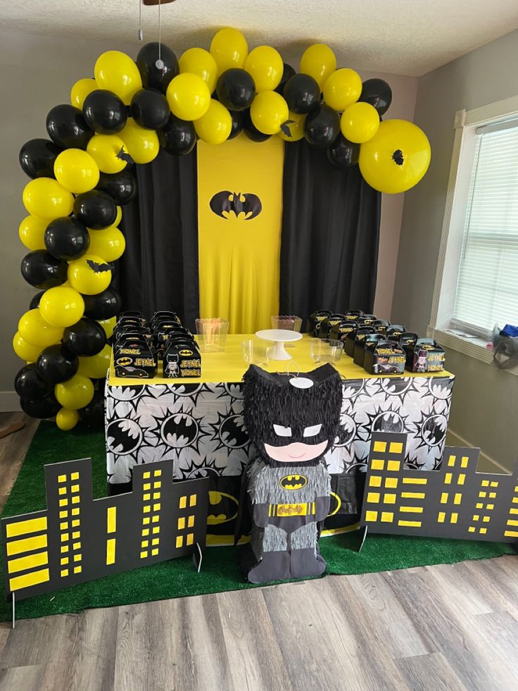 a batman themed party with black and yellow balloons