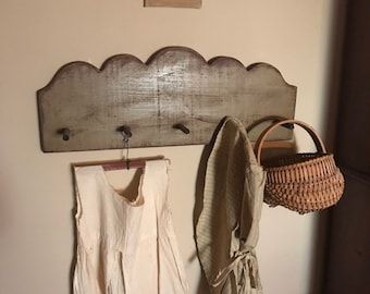 there is a coat rack with two coats hanging on it and a basket next to it