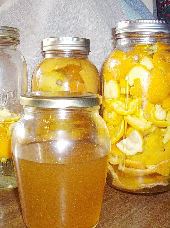 three jars filled with liquid sitting on top of a wooden table