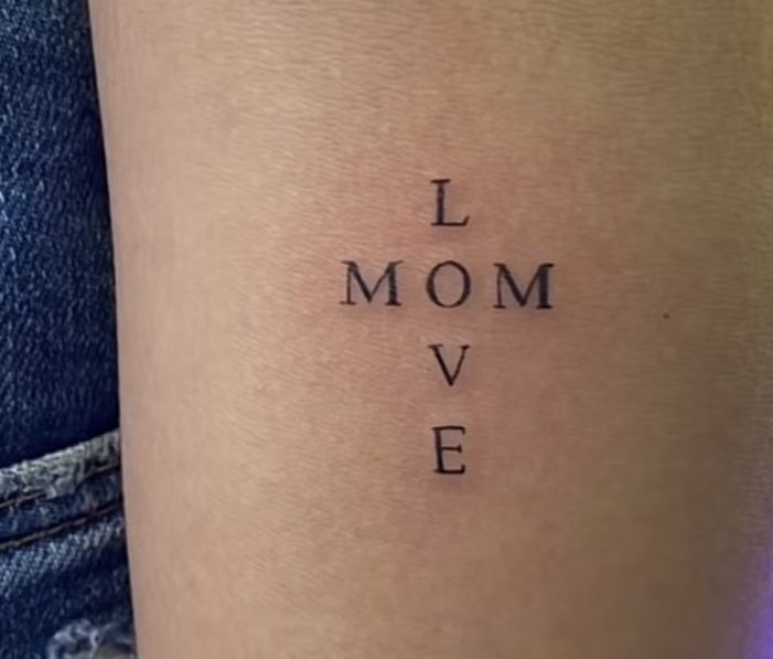 a woman's leg with the words i mom love written on it and in cursive font