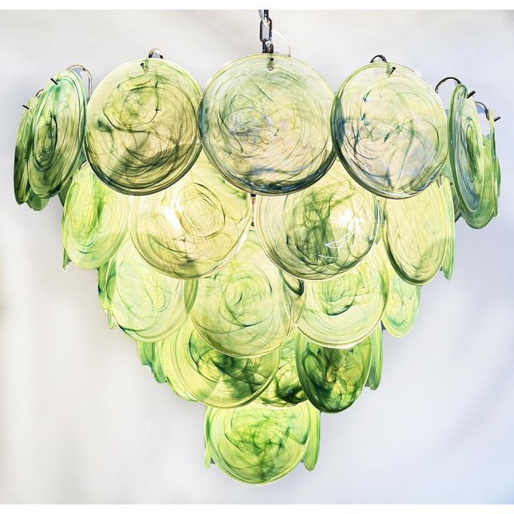 a green chandelier hanging from the ceiling with glass balls in it's center