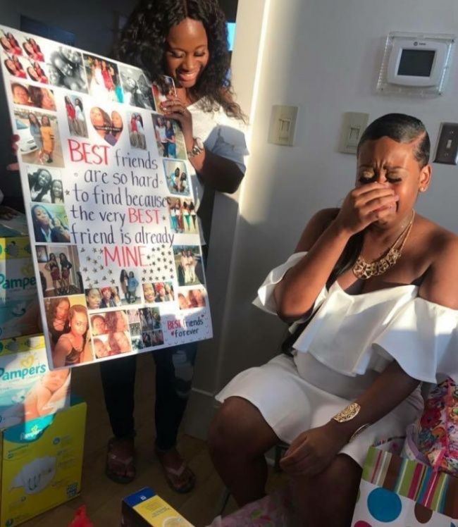 a woman sitting on a chair in front of a sign with pictures and people around her