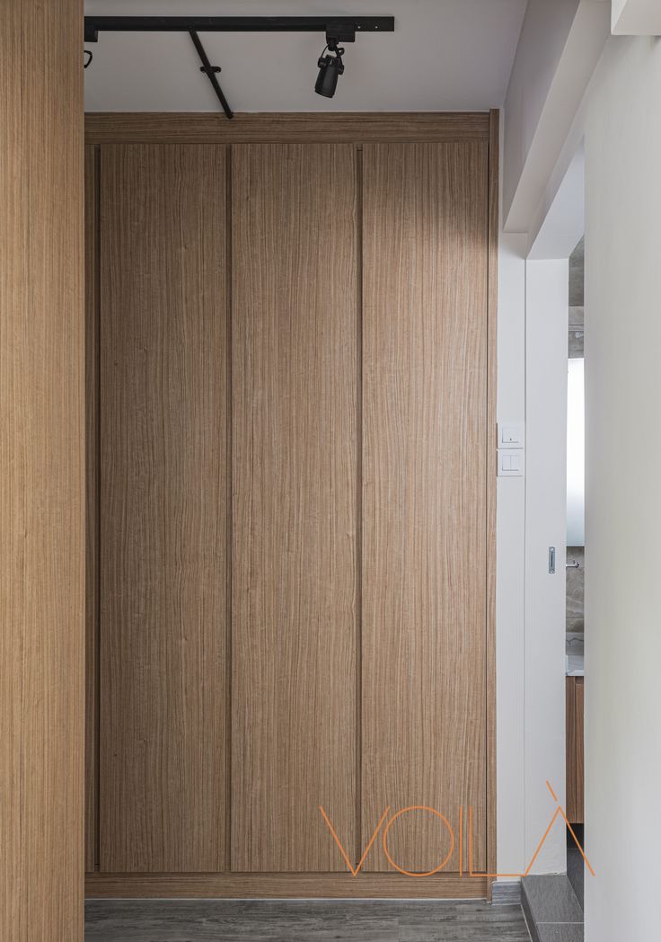 an empty room with wooden closet doors and white walls