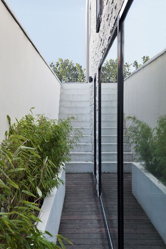 the stairs lead up to the upper level of this modern house, which also has an outdoor deck