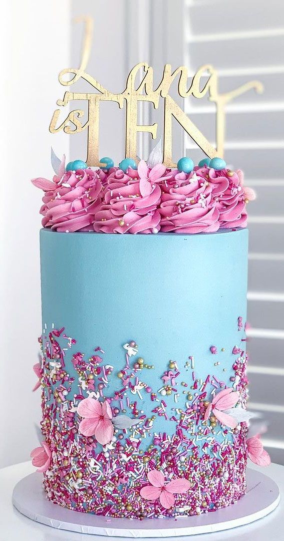 there is a blue and pink cake with flowers on it