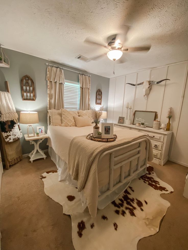 a bed room with a neatly made bed and a cowhide rug on the floor