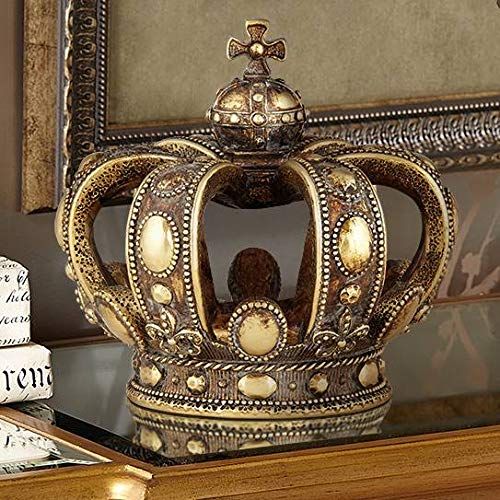 a gold crown sitting on top of a table next to two books and a mirror