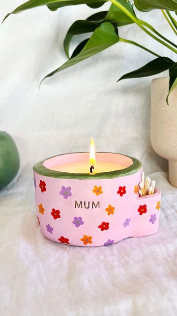 a candle that is sitting on a table next to a potted plant and other items