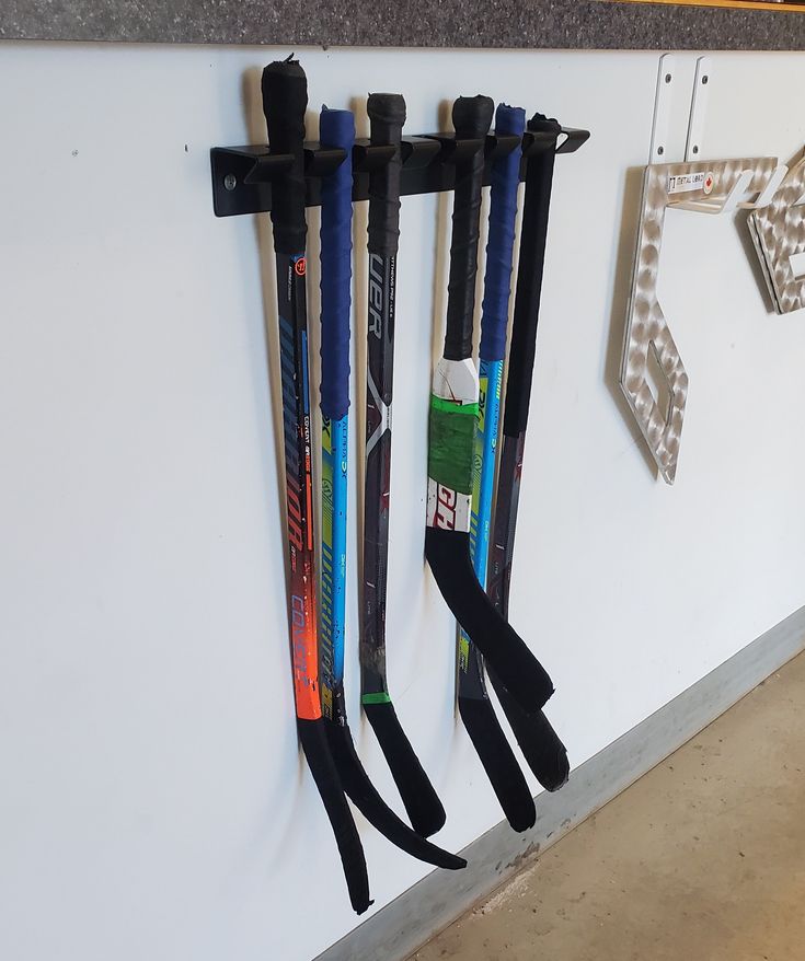 three pairs of skis are hanging on the wall next to each other with their handles down