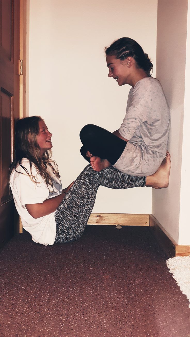 two women are sitting on the floor laughing