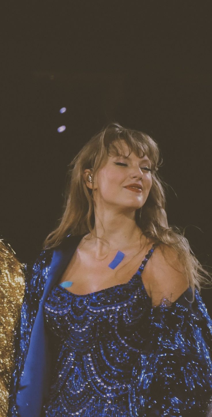 a woman in a blue dress standing on stage