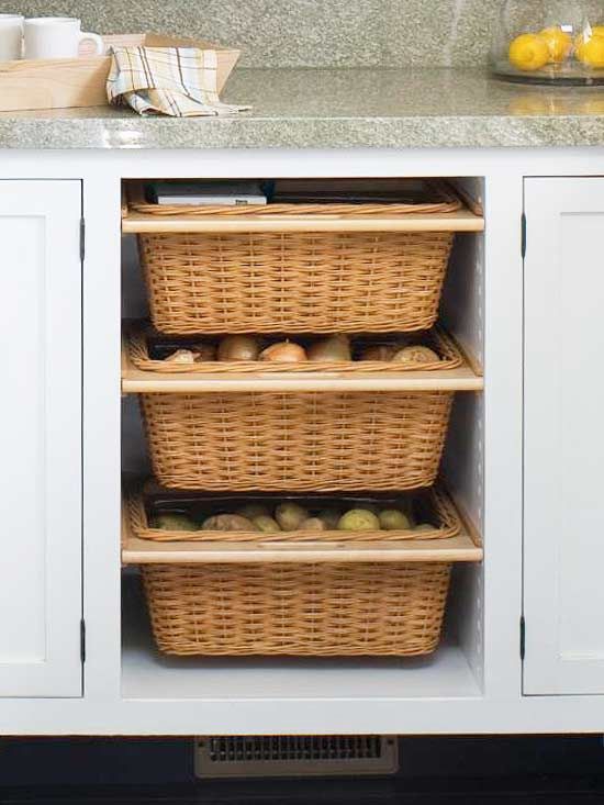 a kitchen with white cabinets and wicker baskets